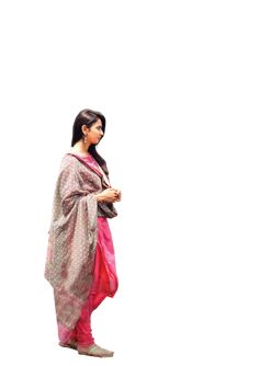 a woman in a pink and grey sari is standing with her hands on her hips