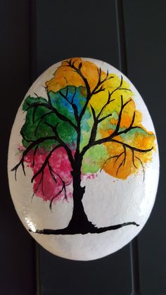 a painted rock with a tree on it