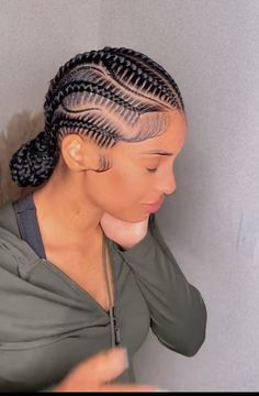 a woman with braids in her hair is looking down at the ground and has one hand on her shoulder