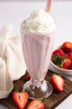 there is a drink with whipped cream and strawberries on the table