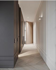 an empty hallway leading to another room with wood paneling on the walls and floor