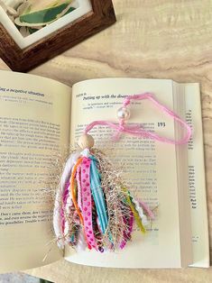 an open book sitting on top of a table next to a bunch of bracelets