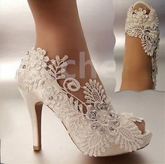 a woman's white high heeled shoes with lace and flowers on the side