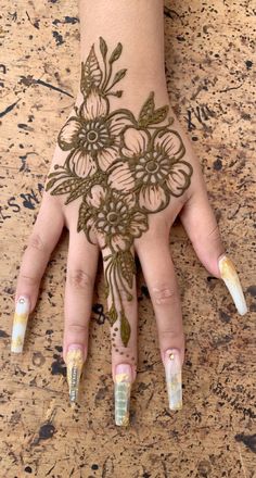 a woman's hand with henna on it and flowers painted on the palm