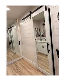 the inside of a bathroom with white walls and wood flooring on the wooden floors