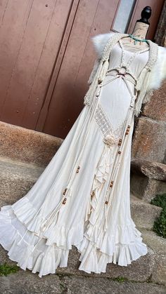 a white dress is on display in front of a red door and some steps outside