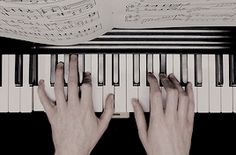 two hands are playing the piano with sheet music