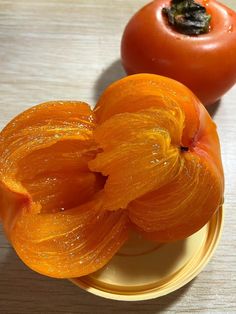 an orange flower sitting on top of a yellow plate next to a red pepper and tomato