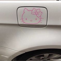 a hello kitty sticker on the side of a silver car with a pink bow