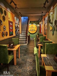 the interior of a restaurant with green chairs and yellow walls, along with stairs leading up to the second floor