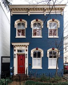 a blue house with red door and windows