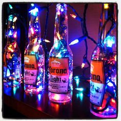 three bottles with lights in them on a table