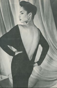 a black and white photo of a woman with her back to the camera, wearing an evening gown