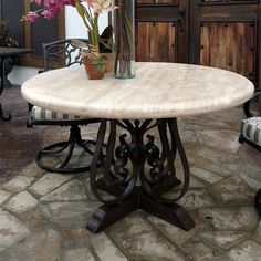 a round table with flowers in a vase on top