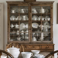 the china cabinet is full of dishes and cups