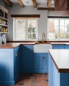 a kitchen with blue cabinets and white counter tops