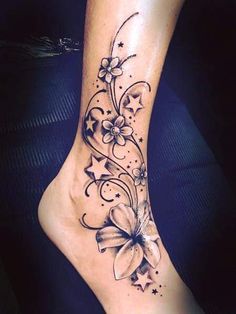 a woman's foot with a flower and stars tattoo on the side of her leg