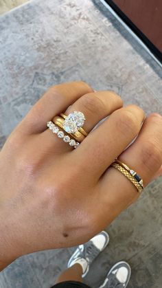 a woman's hand with two different rings on it and one has an engagement ring