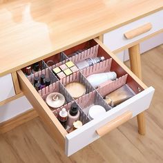 an open drawer on the side of a table with cosmetics and other items in it