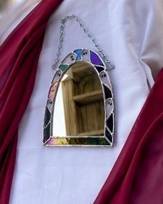 a mirror hanging from a chain on top of a white shirt