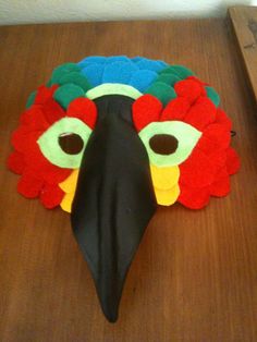 a colorful bird mask sitting on top of a wooden table