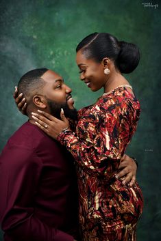 a man and woman embracing each other in front of a green background