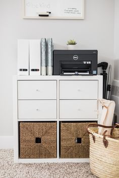 a white dresser with two baskets and a printer on top