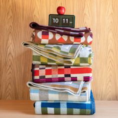 a stack of folded towels sitting next to an apple on top of a wooden table