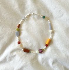 a bracelet with beads and charms on a white sheet