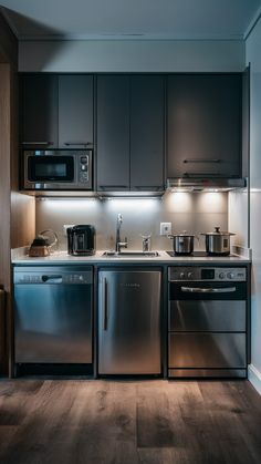 a kitchen with stainless steel appliances and wood flooring is pictured in this image, it appears to be very dark