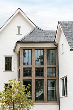 a white house with black windows and brown shutters