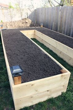 two wooden raised beds with soil in them