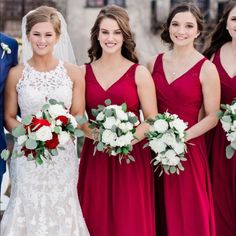 a group of bridesmaids in red dresses and bouquets