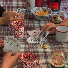 people sitting at a table playing cards and cups