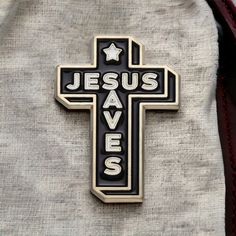 a black and white cross with the word jesus saves written on it is sitting in a bag