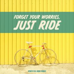 a bicycle parked against a yellow wall with the words forget your worries just ride