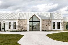 a large white house with a long driveway leading up to the front door and windows