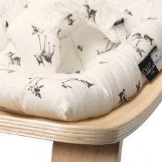 a close up of a baby's seat cushion on a wooden chair with giraffe print