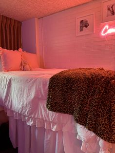 a bedroom with pink lighting and leopard print bedding