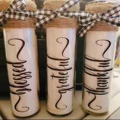 three glass jars with writing on them sitting on a shelf next to some twine