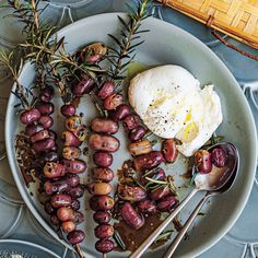 an egg is on top of roasted potatoes and olives with a side of mashed potatoes