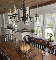 a dining room table with candles and pumpkins on it