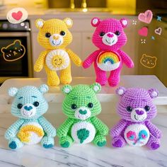 four crocheted teddy bears sitting on top of a counter