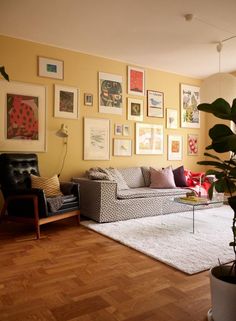 a living room filled with furniture and pictures on the wall