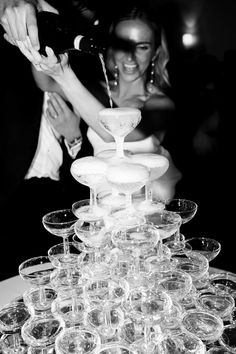 a bride and groom are pouring champagne into wine glasses