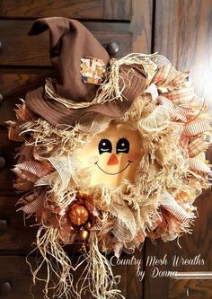 a scarecrow wreath is hanging on the front door