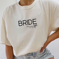 Bride Shirt For Women Comfort Colors, Engagement Gift For Bride, Bride To Be T-Shirt, Bridal Shower Gift, Bridal Shirt, Wifey Shirt Available Colors - Ivory - Bay **Product features** - Constructed with double-needle stitching for durability - Knit in one piece without side seams for a cleaner look - Garment-dyed fabric for a soft color and texture - Made with 100% US cotton for long-lasting comfort **Care instructions** - Machine wash: cold (max 30C or 90F) - Do not bleach - Tumble dry: low heat - Iron, steam or dry: low heat - Do not dryclean **PRODUCTION TIME** 1-3 business days **SHIPPING TIME** 2-5 business days ** For an OVERSIZED fit we suggest sizing up 1-2 sizes from your normal size. ** Our Process ** * We work with a production partner to fulfill each of our items. Items are mad Engagement Shirts, Bridal Shower Shirts, Engagement Gifts For Bride, Wifey Shirt, Engaged Shirts, Bridal Shirts, Bride Shirt, Gift For Bride, Bride Shirts