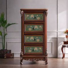 an ornate wooden dresser with flowers painted on the front and sides, in a living room