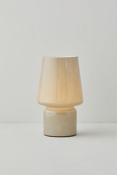 a white table lamp with a beige shade on it