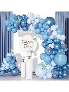 blue and white balloons are on display in front of a photo frame with the words happy day